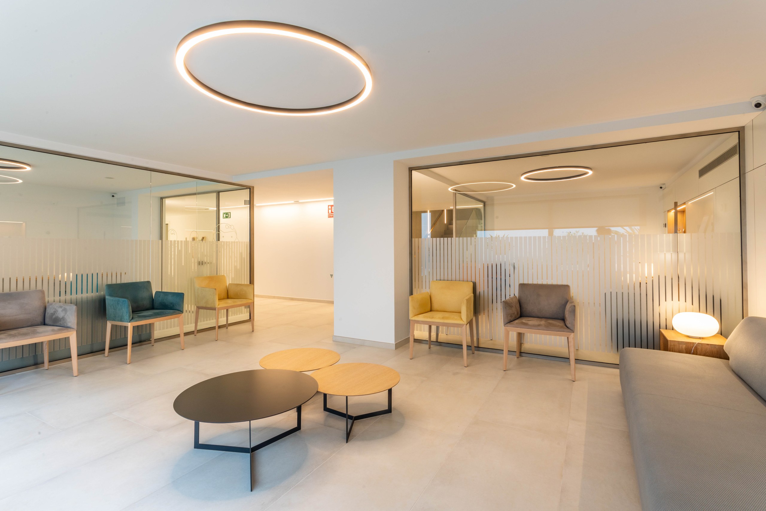 Sala d'espera amb butaques de colors i llum circular, Clínica Mir i Andreu