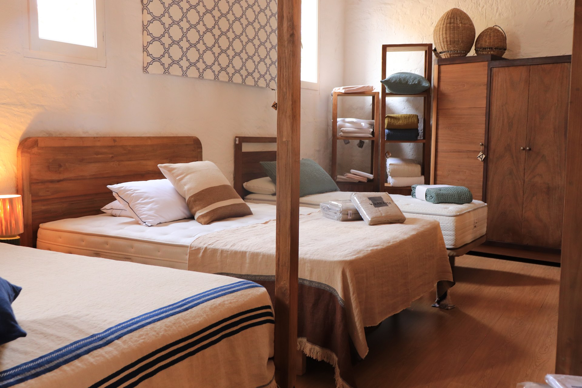 Chambres avec lits en bois et textiles dans la boutique de Ciutadella