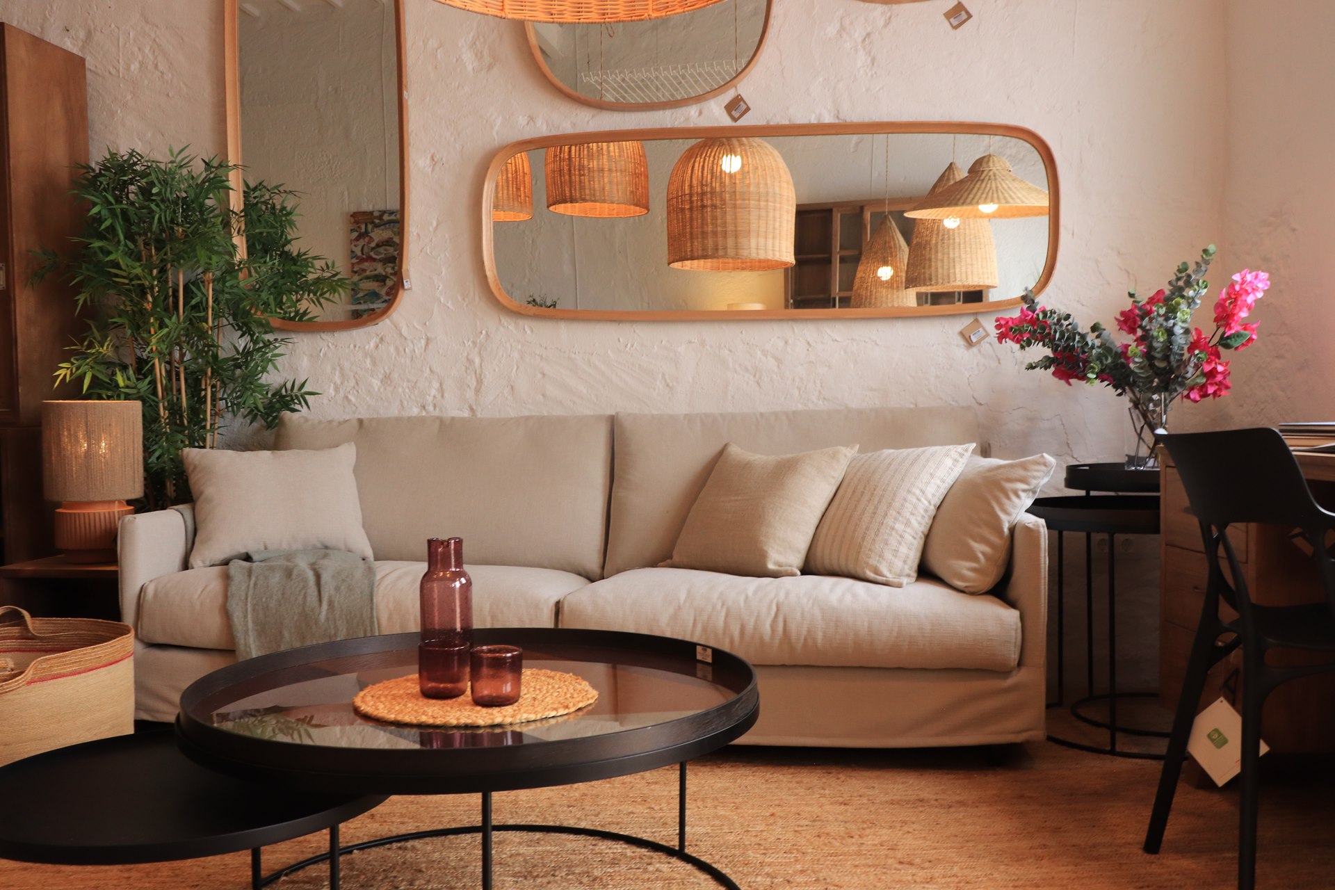 Canapé beige, table basse ronde et miroirs dans la boutique de Ciutadella