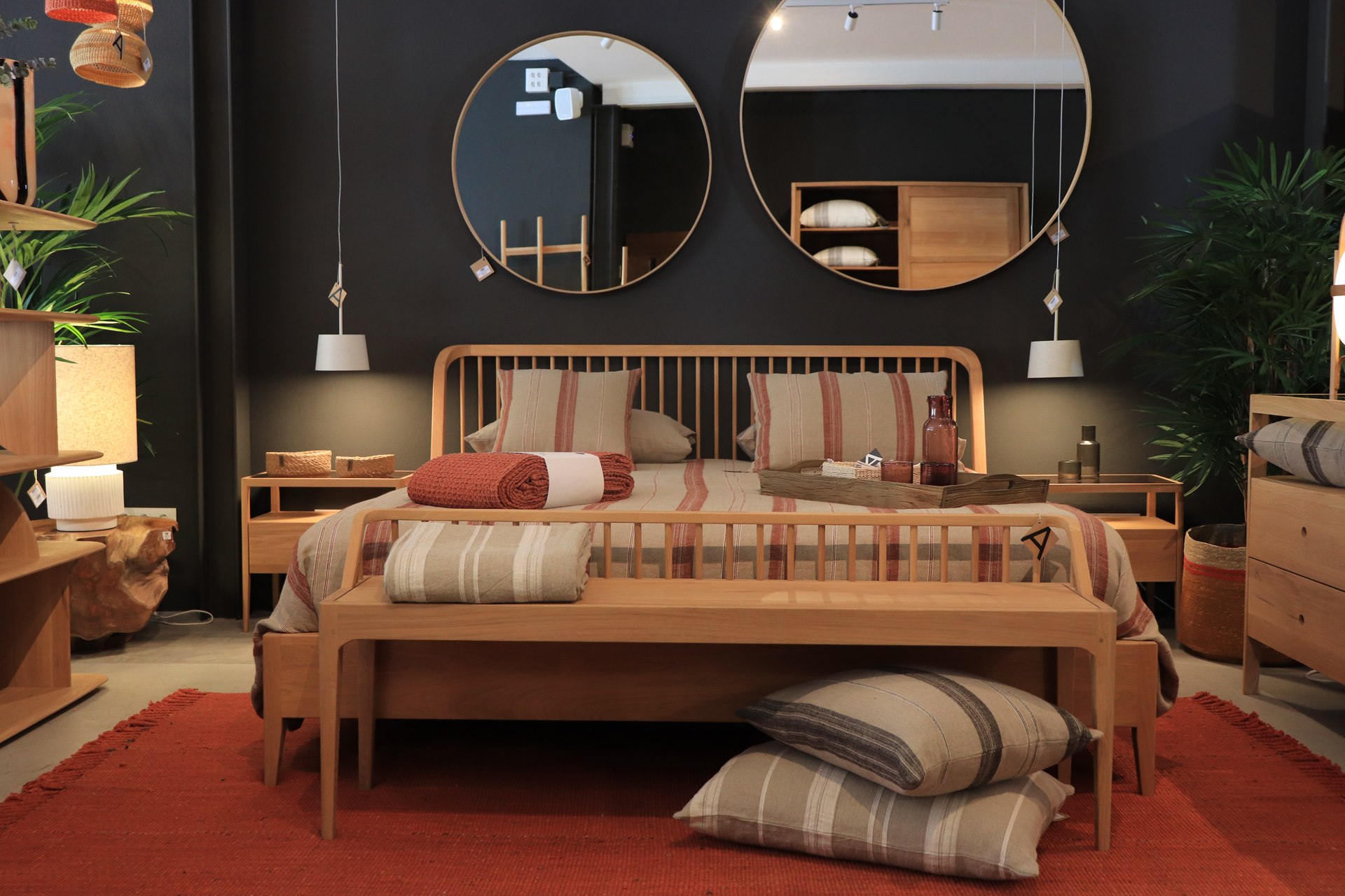 Chambre avec lit en bois et miroirs ronds dans la boutique de Ciutadella