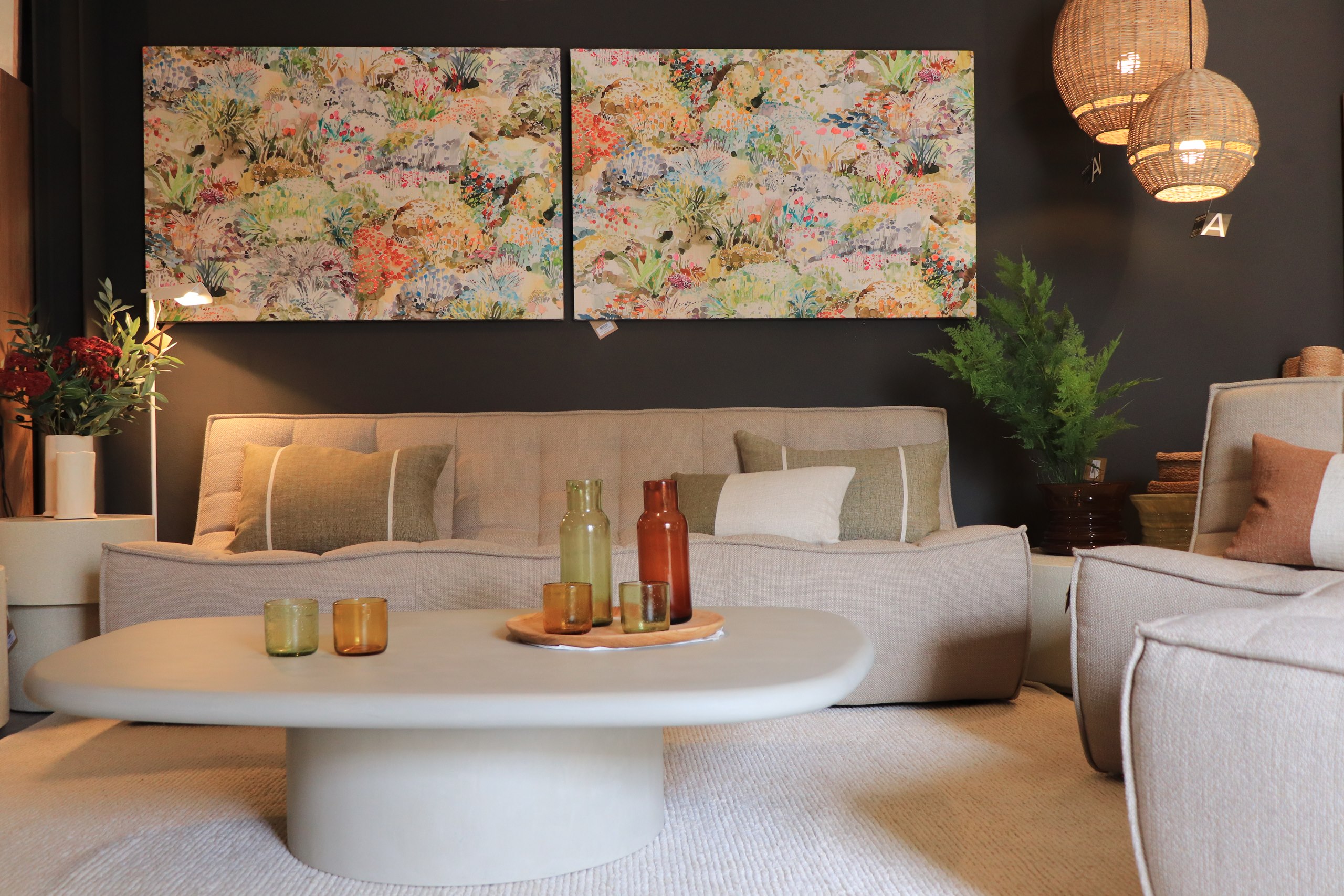 Canapé blanc, table basse et tableaux colorés dans la boutique de Ciutadella