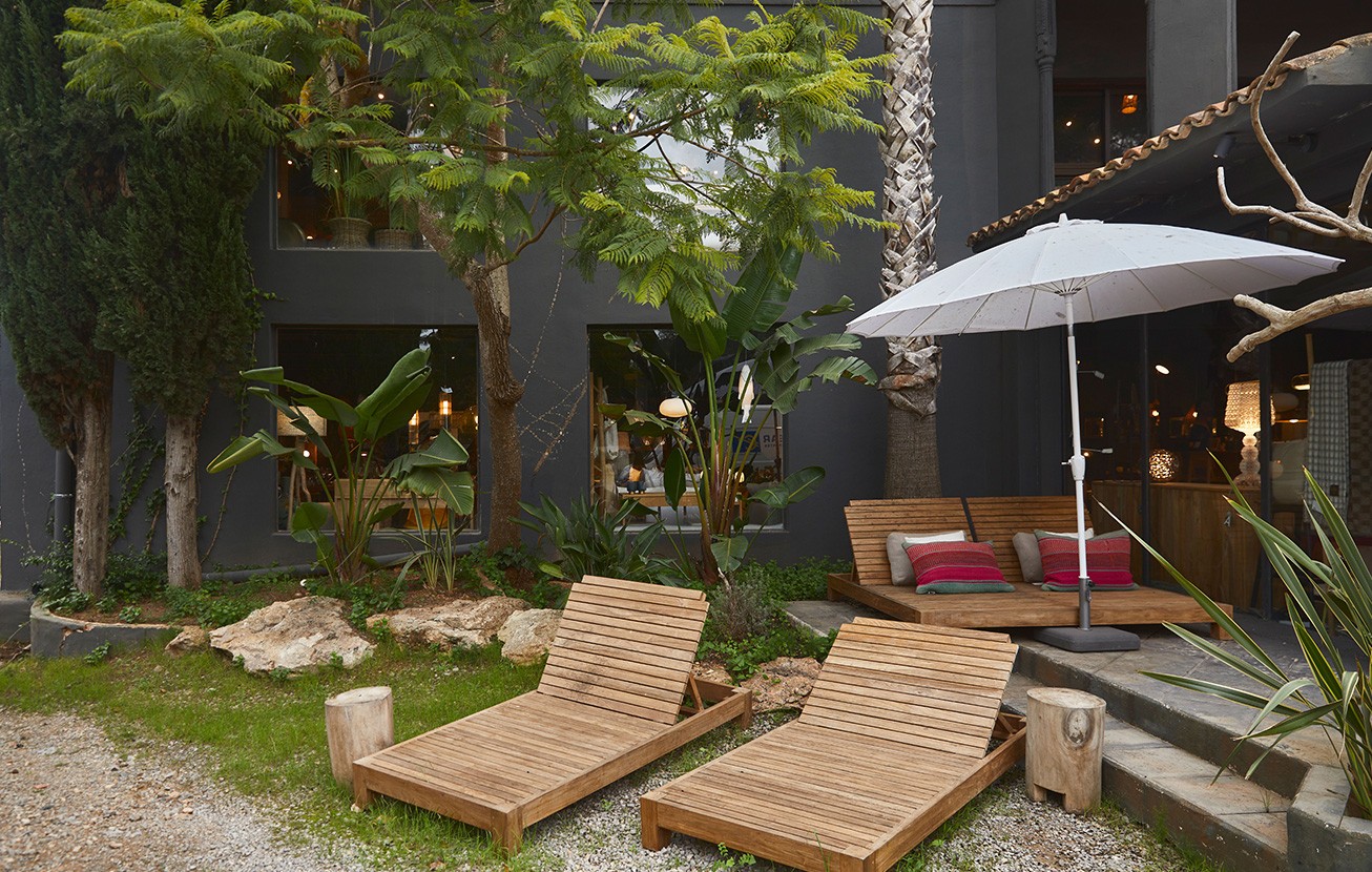 Jardin avec transats en bois et parasol dans la boutique d'Ibiza