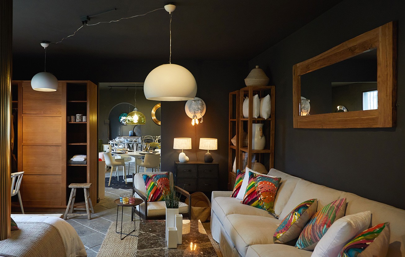 Salon avec canapé, coussins colorés et suspensions dans la boutique d'Ibiza