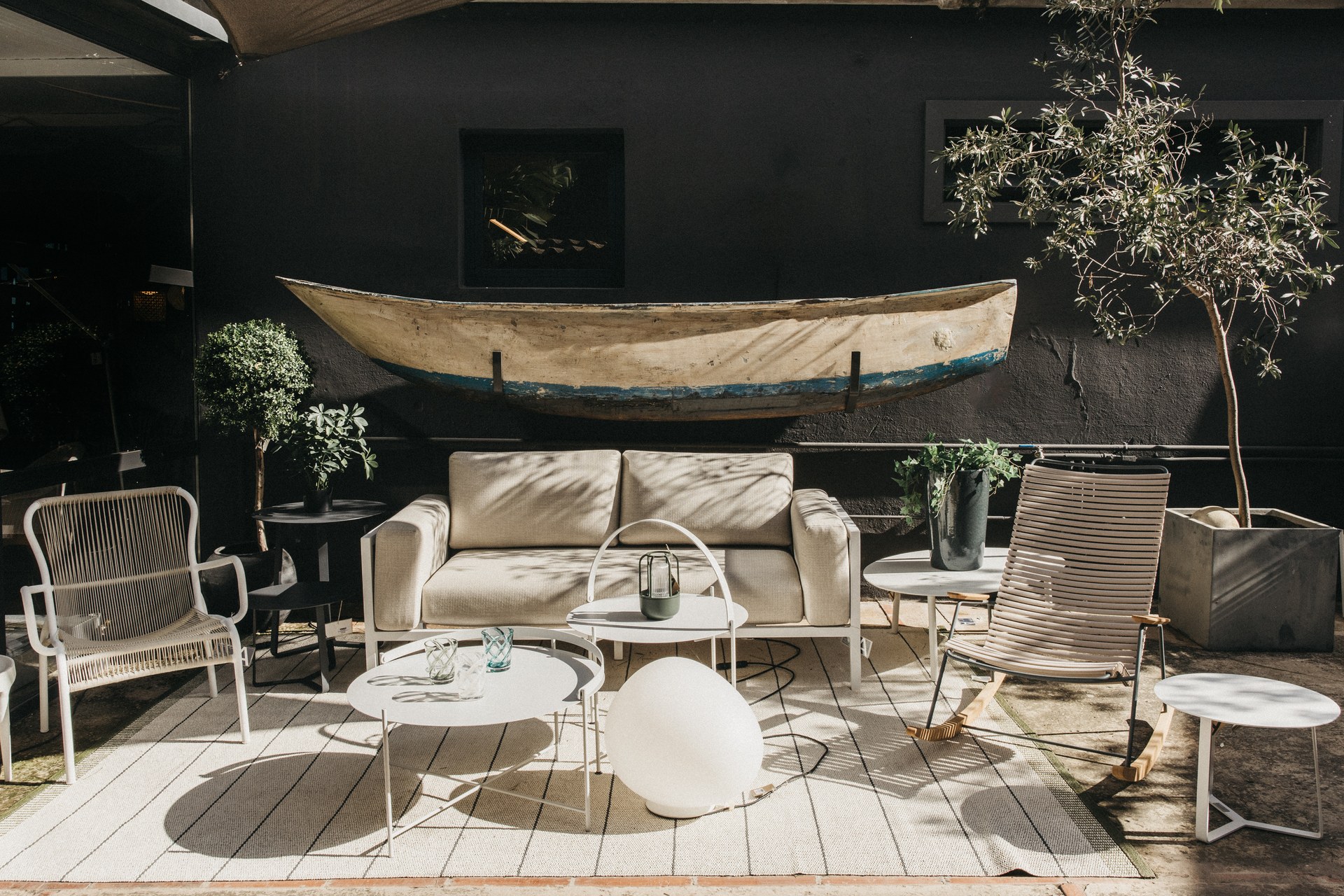 Espace extérieur avec canapé, chaises et tables de jardin dans la boutique de Maó