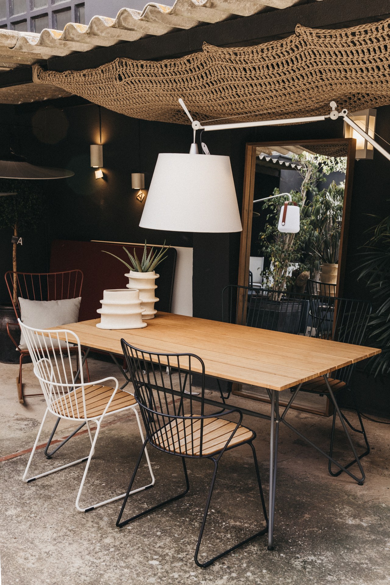 Table d'extérieur en bois avec chaises en métal dans la boutique de Maó