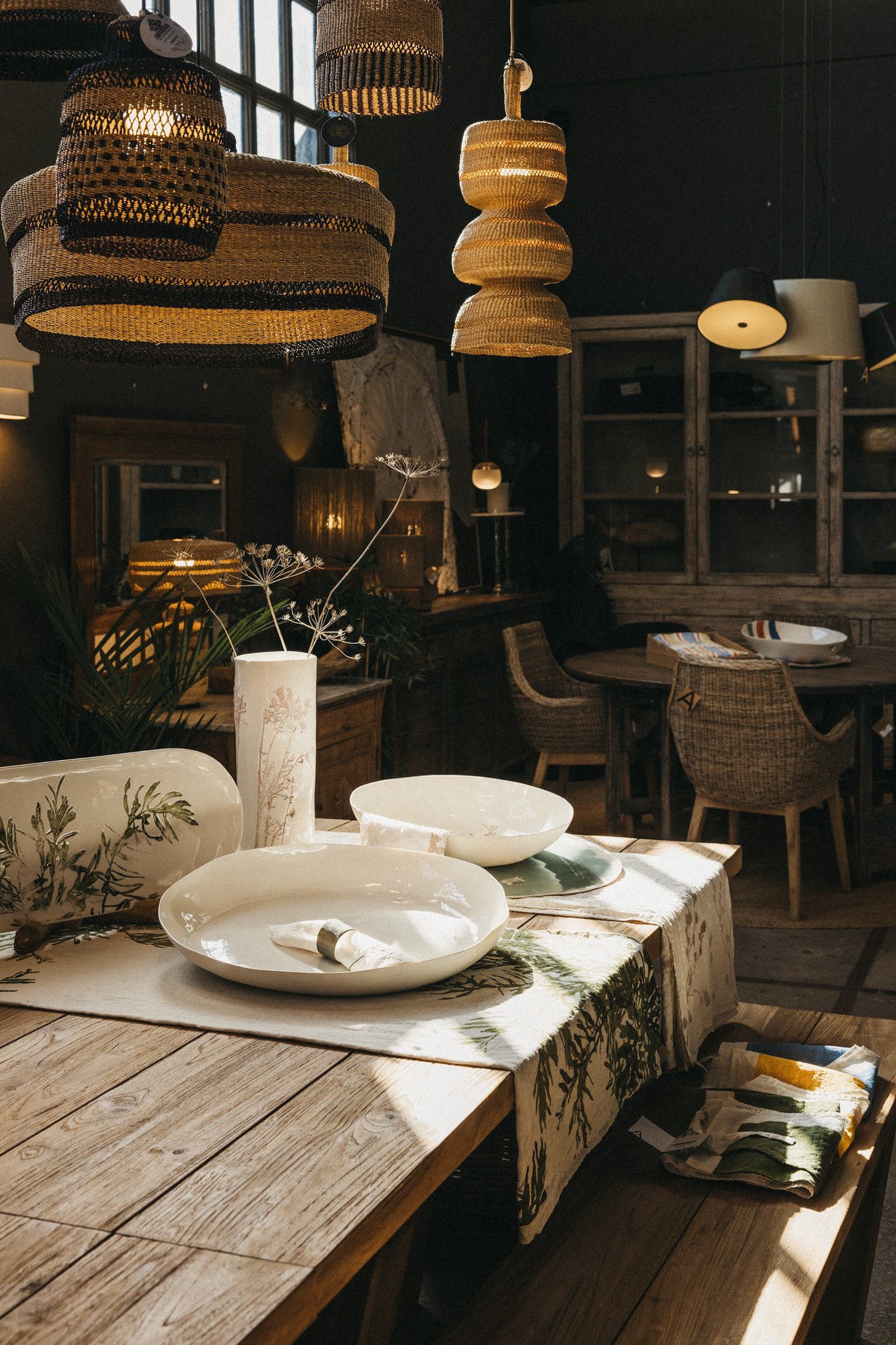 Table en bois avec vaisselle et suspensions en fibre dans la boutique de Maó