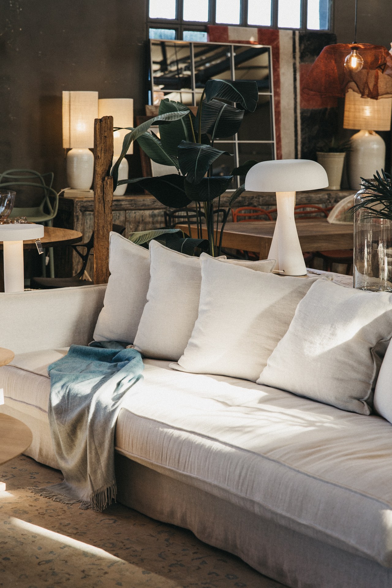Canapé blanc avec coussins et lampe de table dans la boutique de Maó